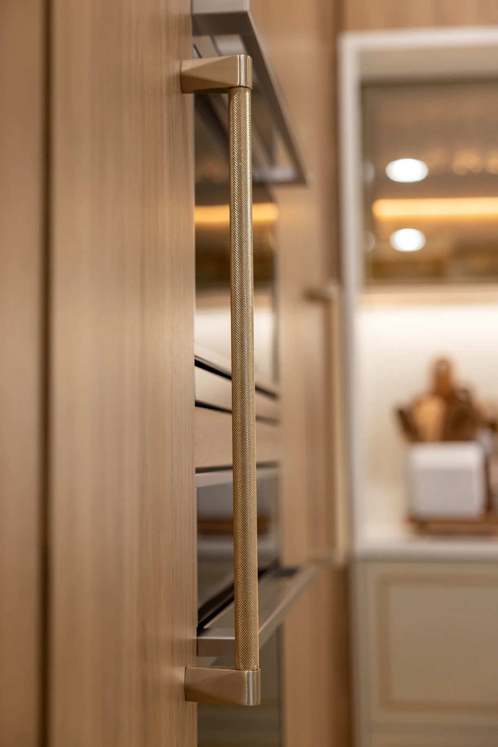 Knurled brass appliance pull on oak panelling